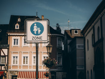 Low angle view of road sign against buildings in city