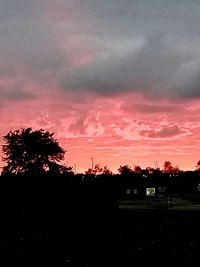 Silhouette trees against dramatic sky during sunset