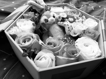 Close-up of roses and stuffed toy in container