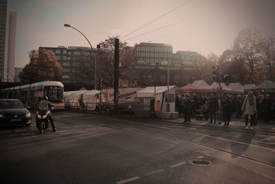 People on city street against sky