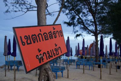Close-up of information sign against trees