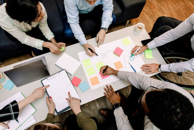 High angle view of professionals planning sales strategies during meeting in office