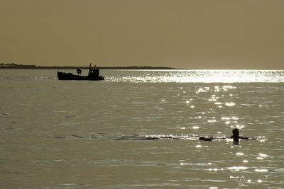 Boat in sea at sunset