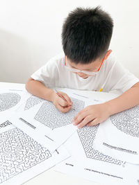 High angle view of boy sitting on table