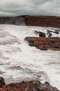 Scenic view of rocks in water against sky