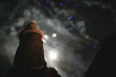 Rear view of woman looking at illuminated nightclub