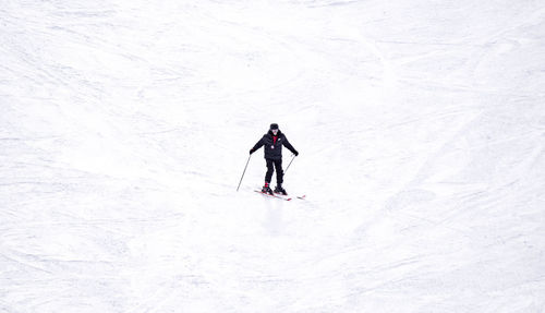 Full length of woman skiing on snowcapped mountain