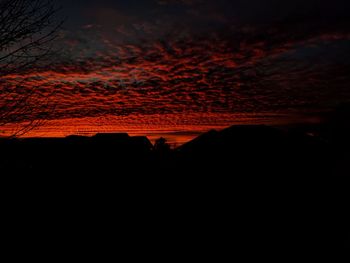 Scenic view of silhouette trees against dramatic sky at sunset