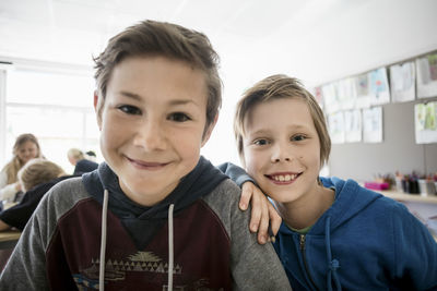 Portrait of happy schoolboys sitting in classroom