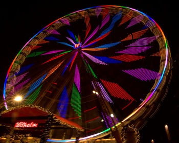 Low angle view of illuminated ferris wheel against sky at night