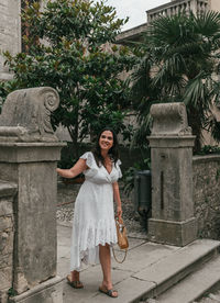 Full length portrait of young woman in white dress in old town of labin, croatia