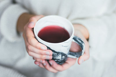 Red tea hot drink on cold day person in pullover winter