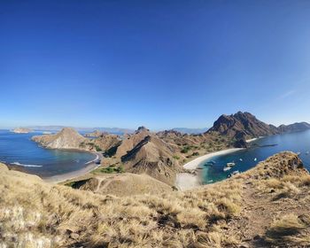 Panoramic view of sea and mountains against clear blue sky