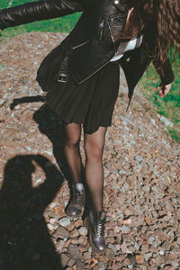 Low section of young woman walking on stones