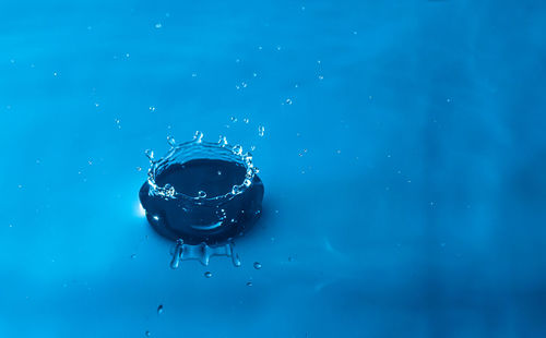 Close-up of water drop on blue surface