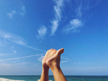 Low angle view of person against sea against blue sky