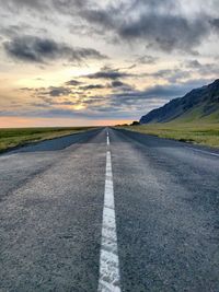 Empty road against sky during sunset