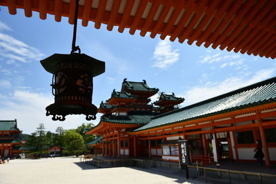 Low angle view of lanterns hanging by building against sky