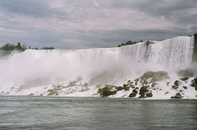 Scenic view of waterfall against sky