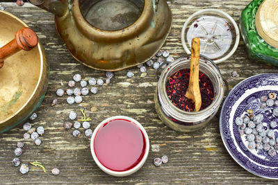 Rustic japanese copper tea kettle, filled tea cup, juniper berries