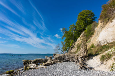 Scenic view of beach amidst mountain against clear blue sky during sunny day