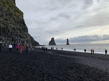 People at beach against sky