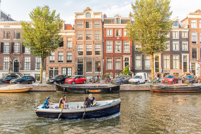 Boats in canal amidst buildings in city