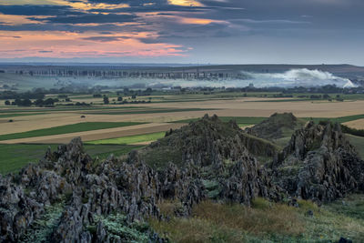 Panoramic shot of agricultural field against sky during sunset