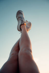 Low section of woman legs against clear sky