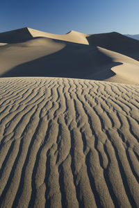 Scenic view of sand dunes against sky