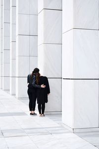 Rear view of women standing by columns