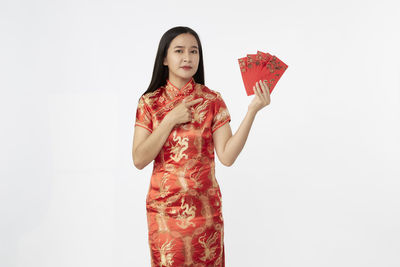 Young woman holding umbrella against white background