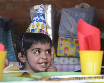 Close-up of boy wearing party hat at home