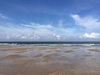 Scenic view of beach against blue sky