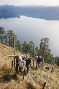 People on mountain against lake