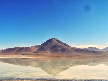 Scenic view of mountains against blue sky