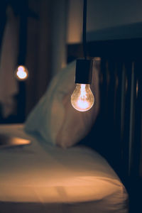 Close-up of illuminated light bulb in bedroom