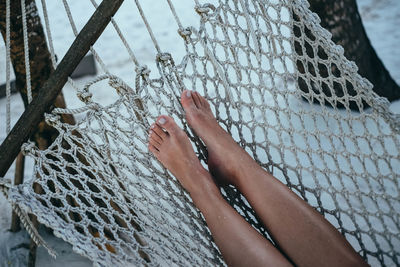 Low section of woman relaxing on hammock