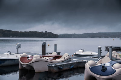 Boats moored in lake against sky