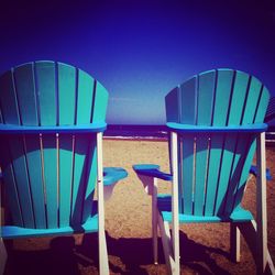 Empty chairs and tables at seaside