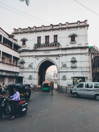 People on street against buildings in city