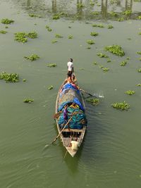 Rear view of man on fishing boat in river