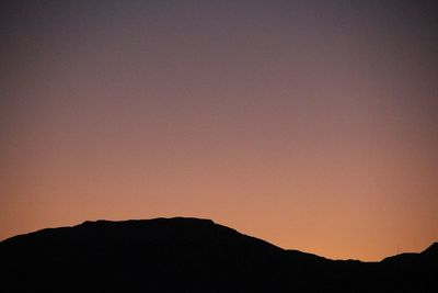 Silhouette mountains against clear sky at sunset