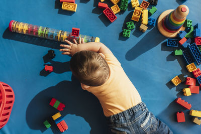 High angle view of boy playing with toy toys