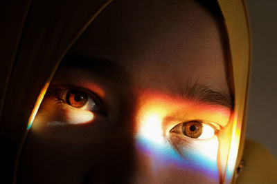 Close-up portrait of woman with spectrum on eye