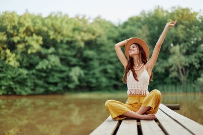 Side view of woman sitting on pier