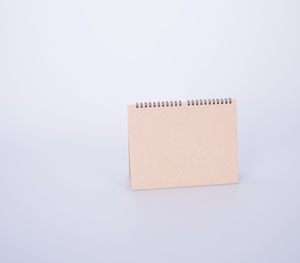 High angle view of blank brown desk calendar on white background