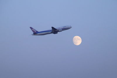 Low angle view of airplane against clear blue sky