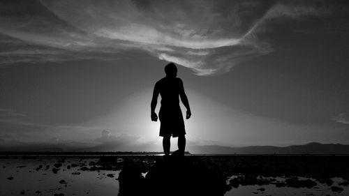 Rear view of silhouette man standing on beach