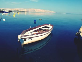 High angle view of boat moored in sea against blue sky